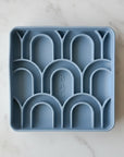 Blue silicone ice cube tray with geometric design on a white background