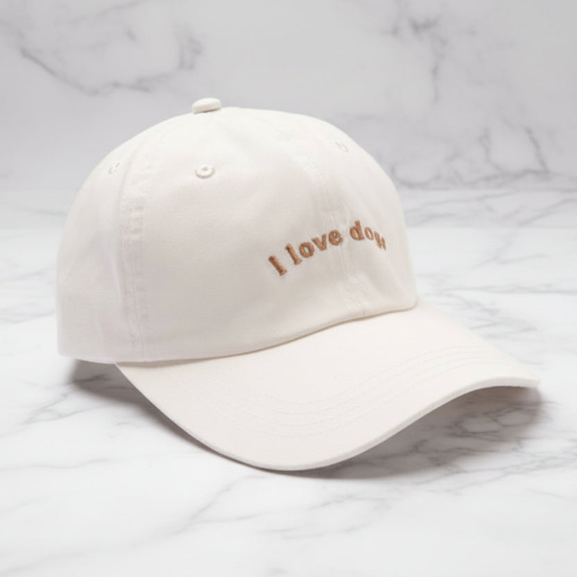 Beige cap with 'I love dogs' embroidery on a light gray background