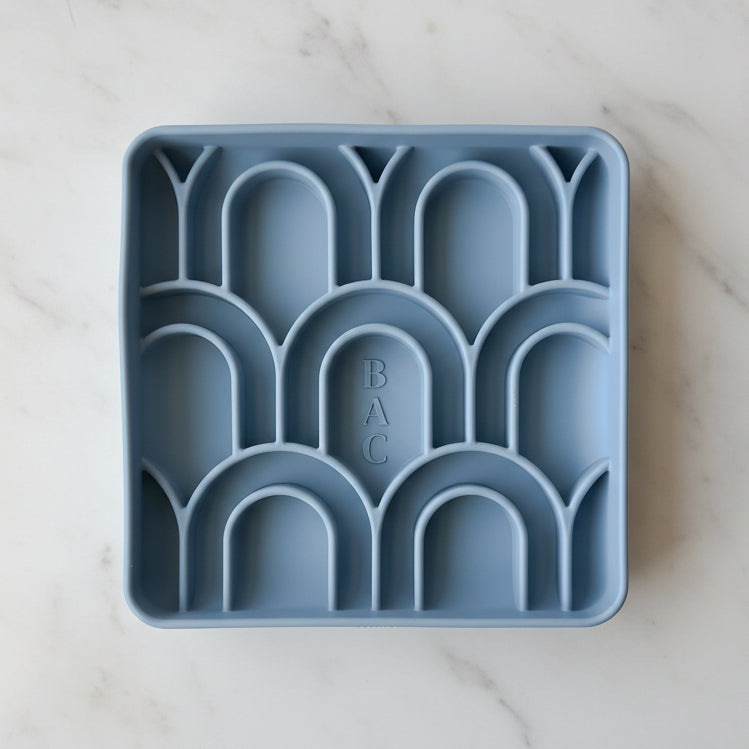 Blue silicone ice cube tray with geometric design on a white background