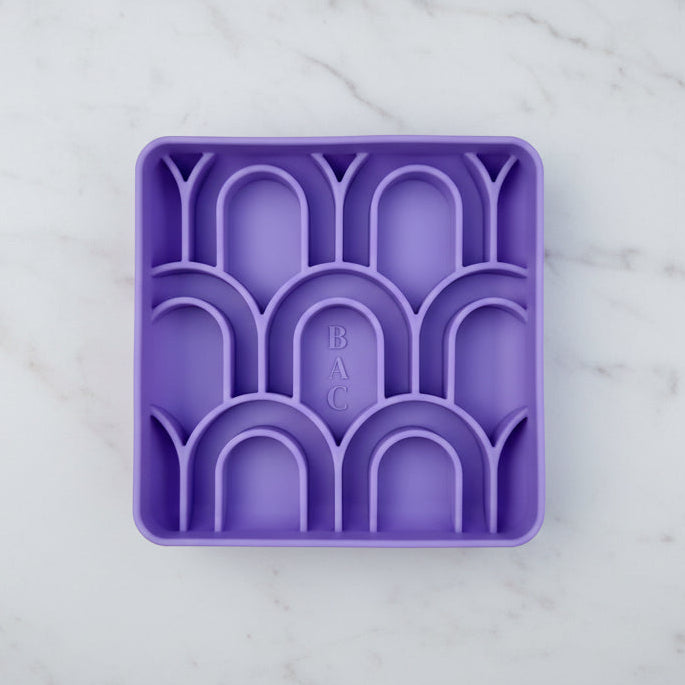 Purple silicone bowl with geometric design on a light purple background