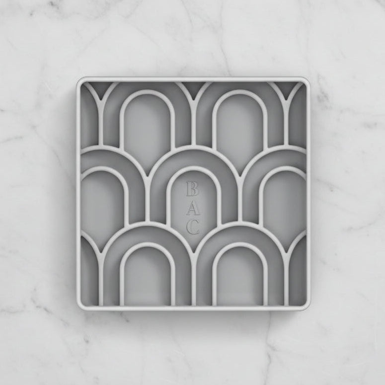 Decorative gray tray with arches and 'BAC' branding on a white background