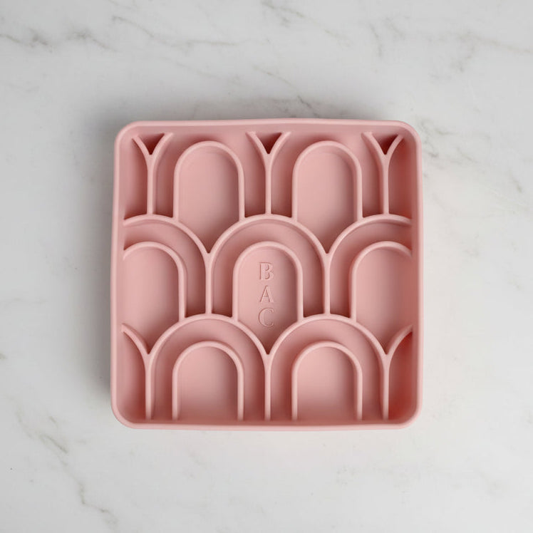 Pink silicone ice cube tray with arch-shaped molds