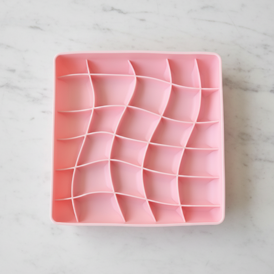 Pink silicone mold with wavy patterns on a white background