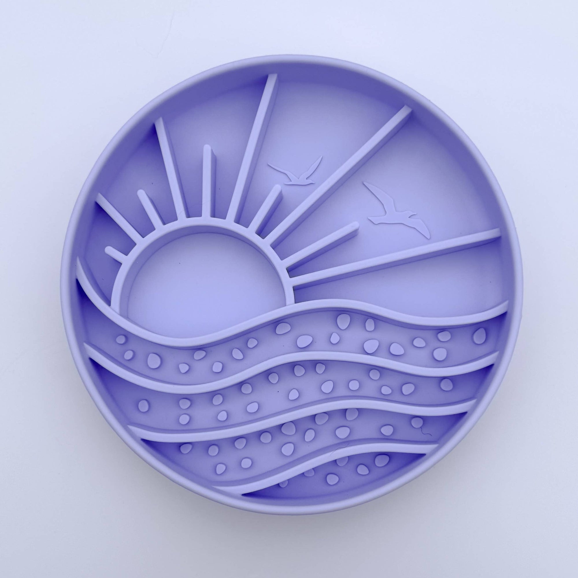 Round purple silicone mold with sun and wave design on a light purple background